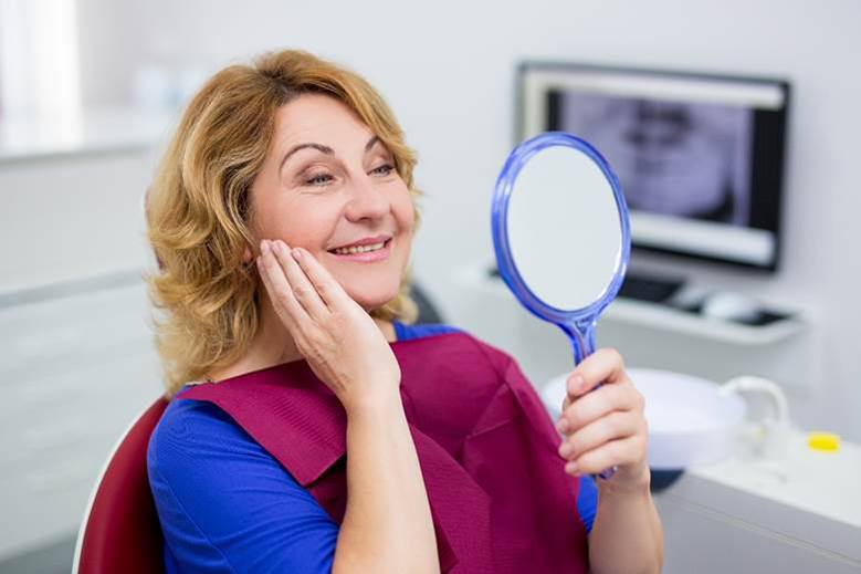 woman admiring her new smile after dental bonding