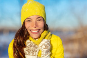 a woman smiling during the winter with a healthy mouth